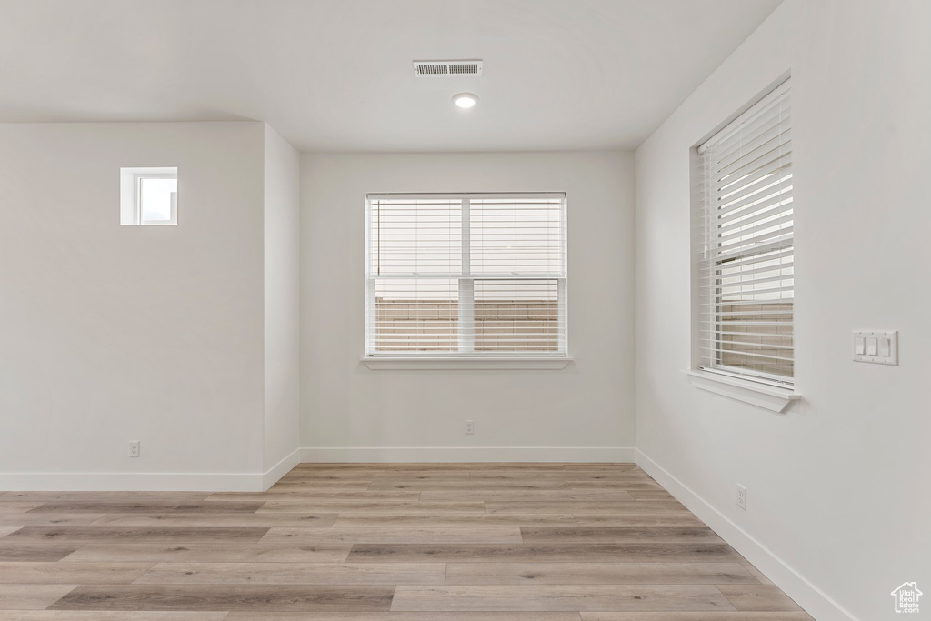 Spare room featuring baseboards and light wood finished floors