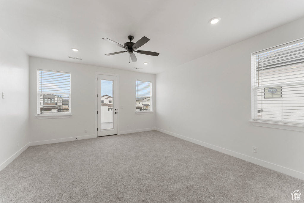 Empty room with ceiling fan, light carpet, baseboards, and recessed lighting