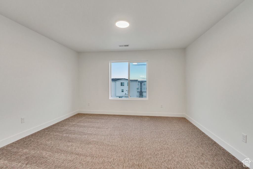 Unfurnished room featuring carpet floors and baseboards