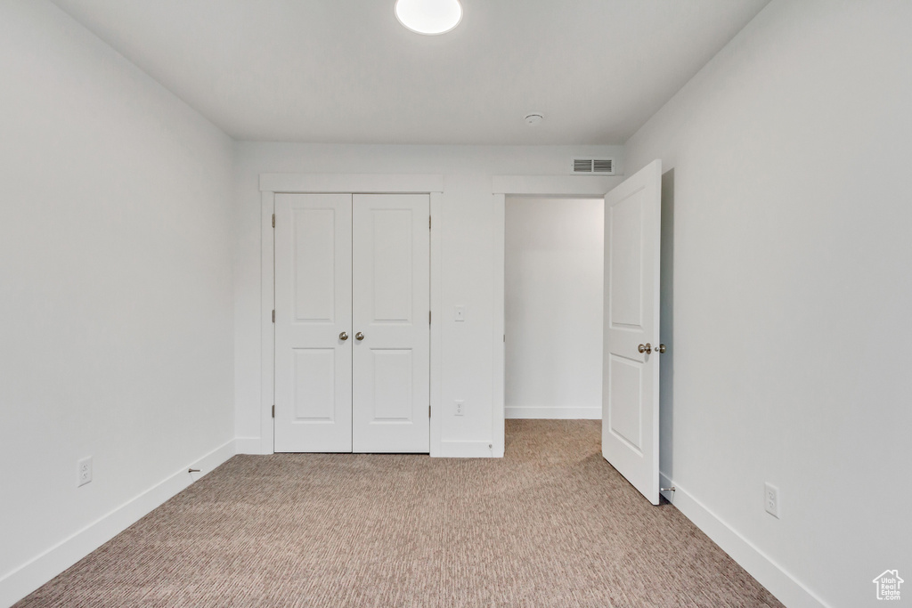 Unfurnished bedroom with carpet flooring, a closet, and baseboards