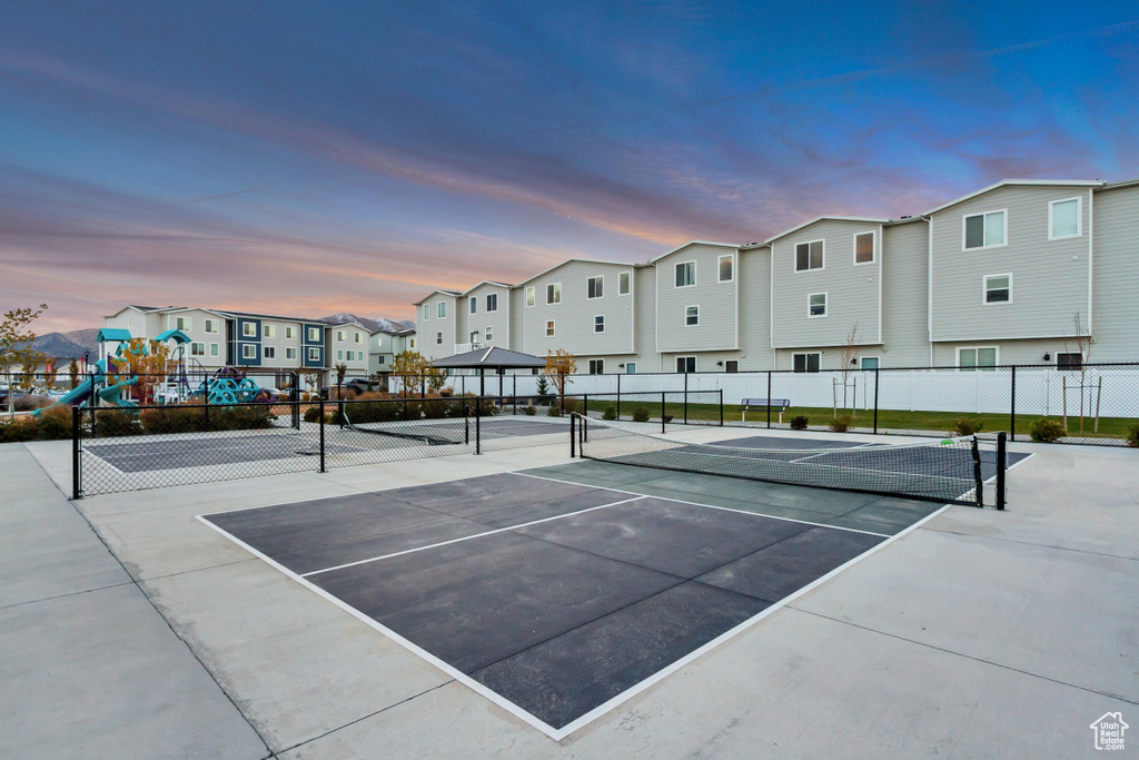 View of tennis court with a residential view
