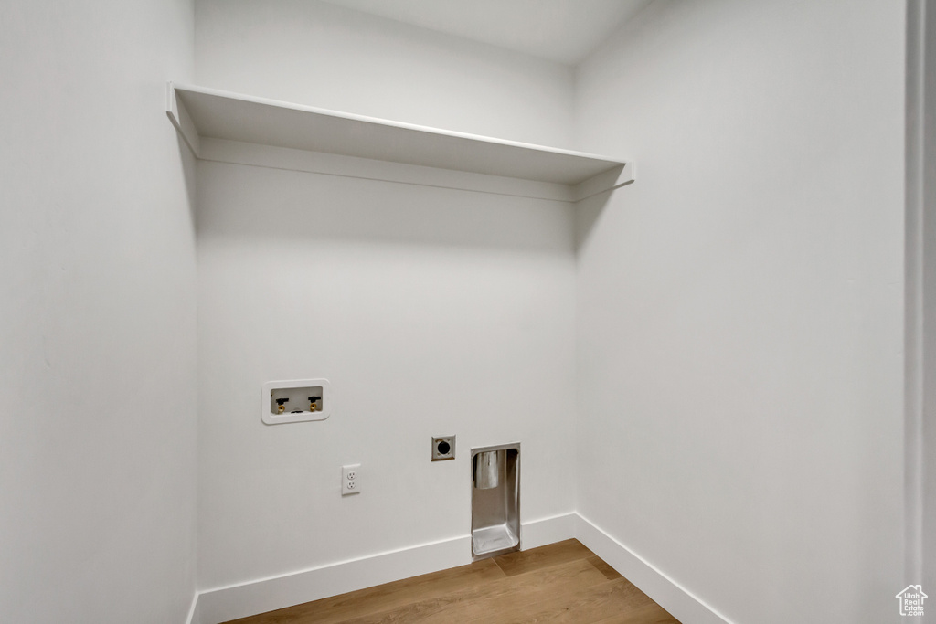 Laundry room featuring hookup for a washing machine, wood finished floors, hookup for an electric dryer, and baseboards