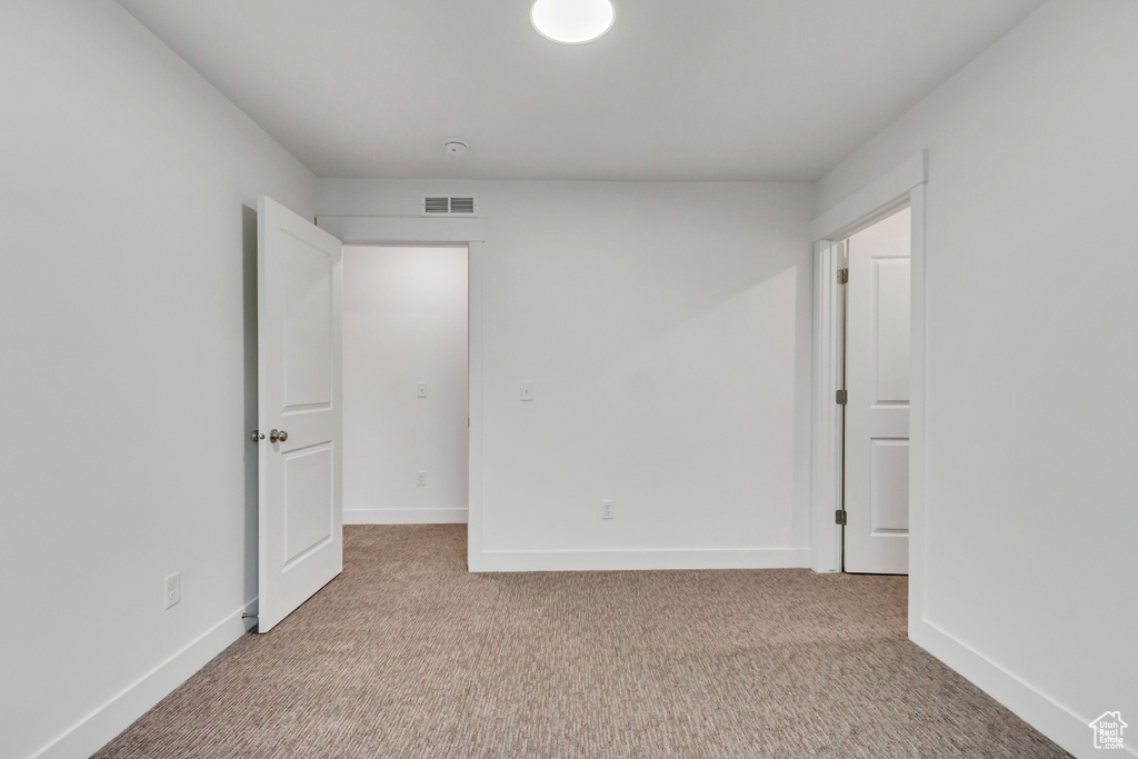 Empty room featuring carpet and baseboards
