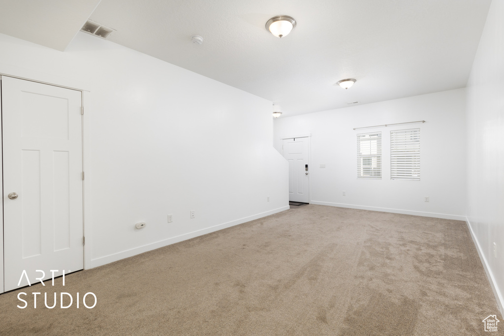 Carpeted empty room featuring baseboards and a smoke detector