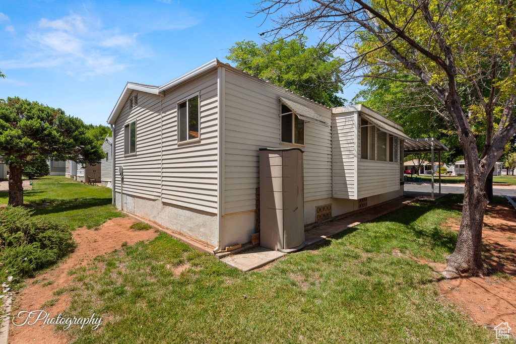 View of side of property featuring a yard