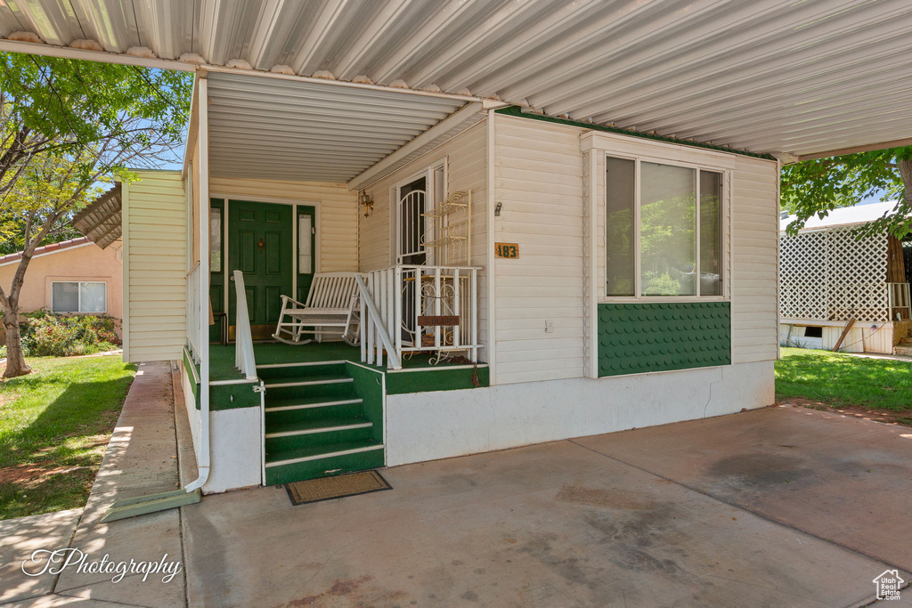 Doorway to property featuring covered porch
