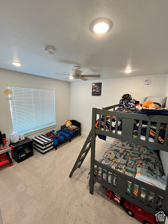 Bedroom featuring carpet flooring, a ceiling fan, and a textured ceiling