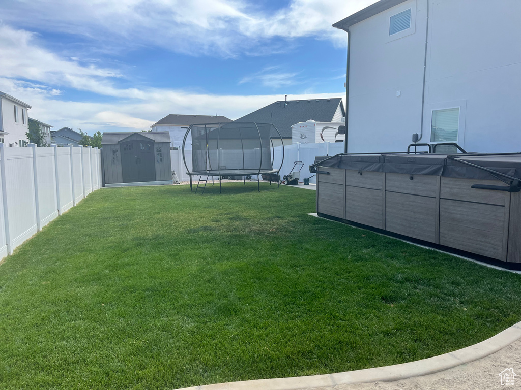 View of yard with a trampoline, a swimming pool, and a residential view