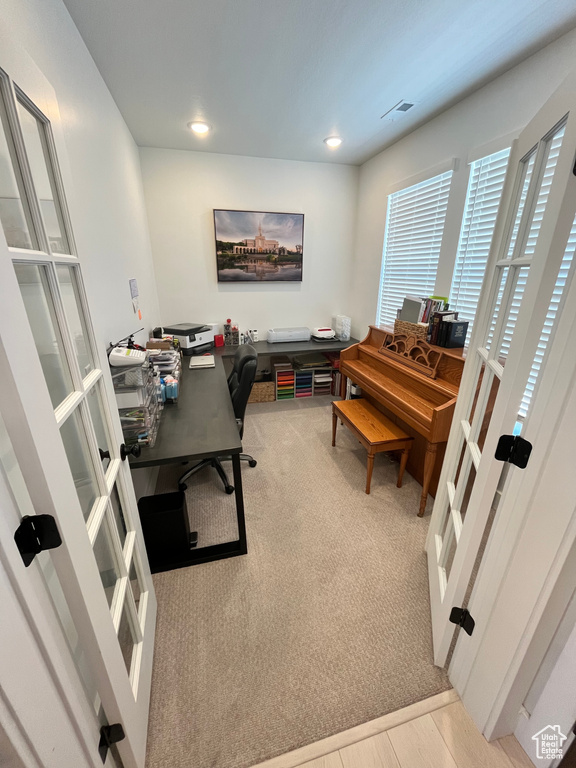 Carpeted office with french doors and recessed lighting