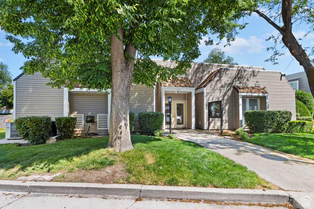 View of front of property featuring driveway and a front yard