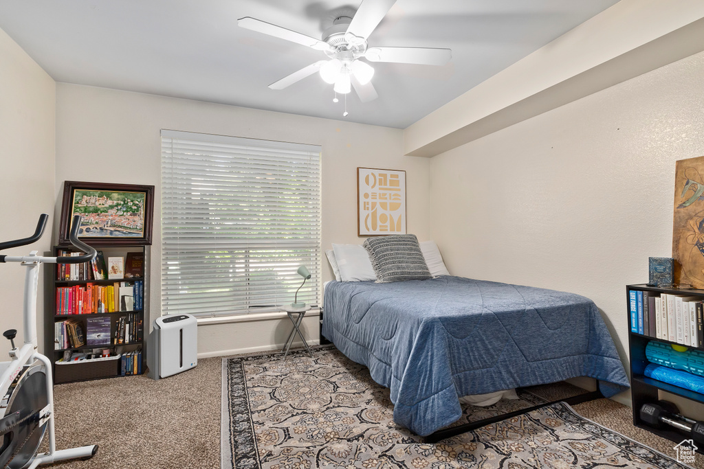 Carpeted bedroom with ceiling fan and baseboards