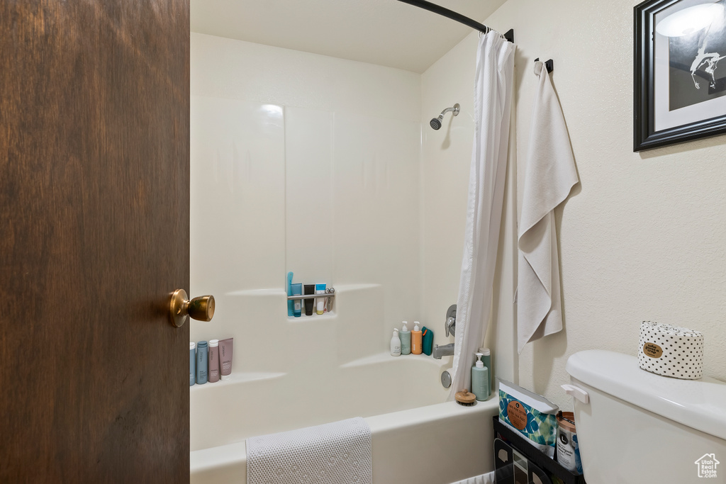 Full bath featuring shower / bathtub combination with curtain and toilet