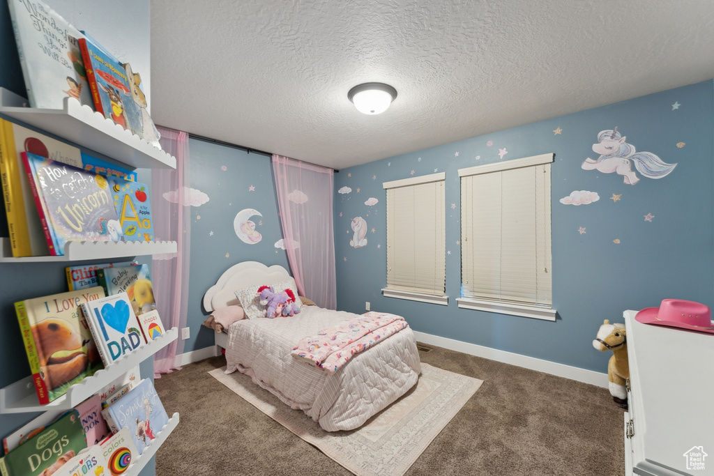 Bedroom featuring a textured ceiling, carpet, and baseboards