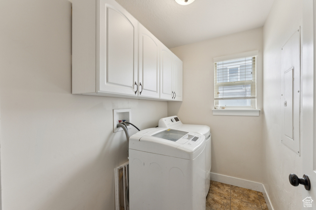 Washroom with separate washer and dryer, cabinet space, and baseboards