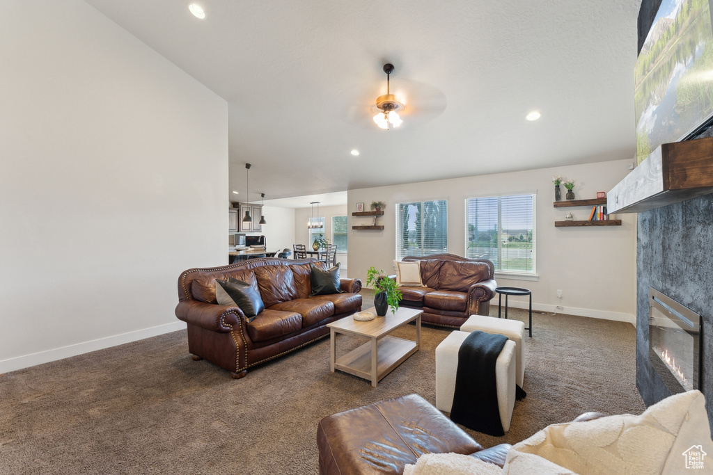 Living room with a fireplace, carpet floors, baseboards, recessed lighting, and a ceiling fan