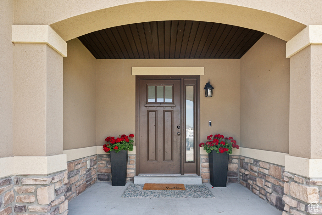 View of exterior entry featuring stucco siding and stone siding