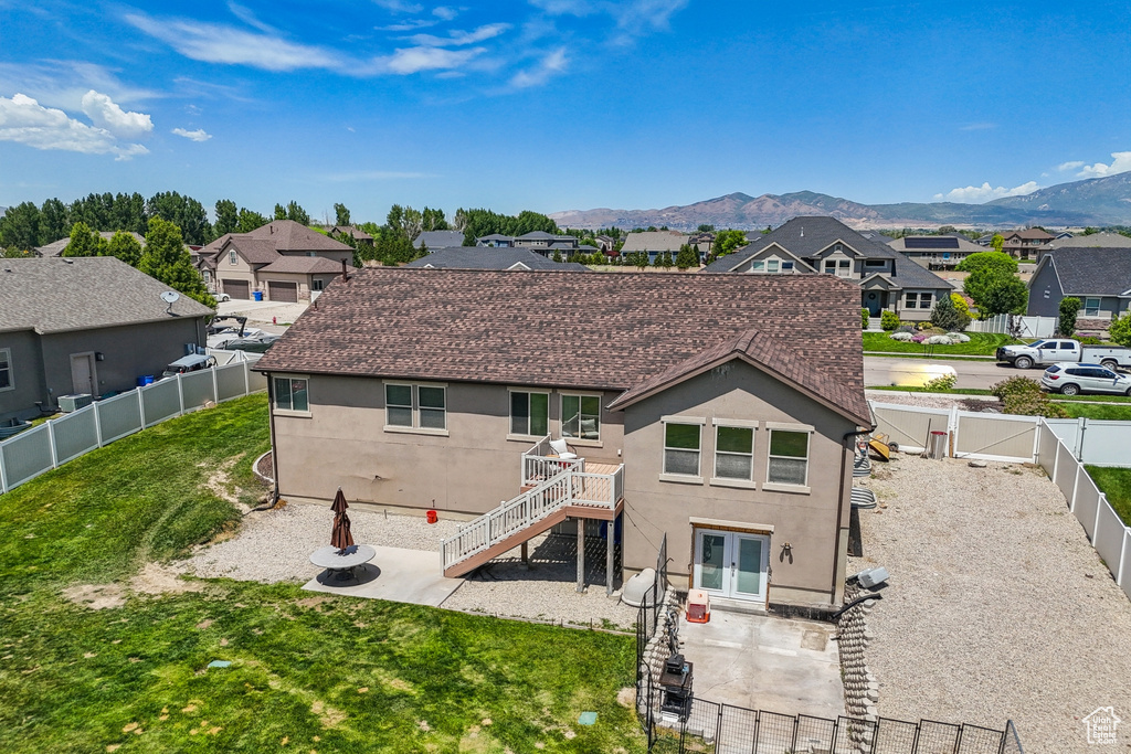 Rear view of house with a residential view, a patio, a gate, and stucco siding