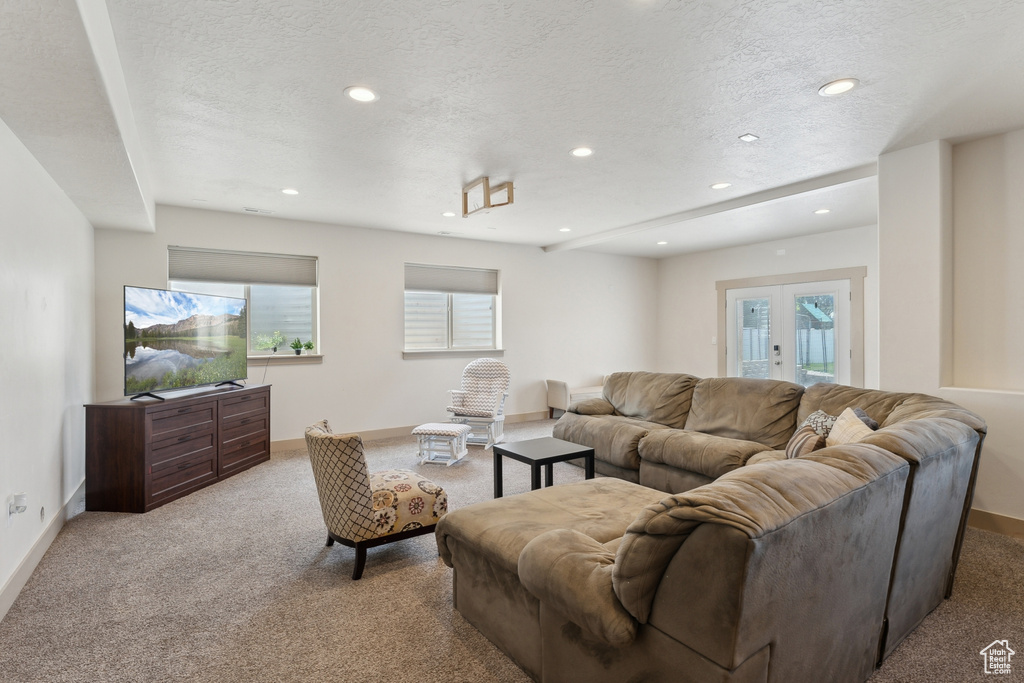 Carpeted living area featuring baseboards, recessed lighting, plenty of natural light, and a textured ceiling