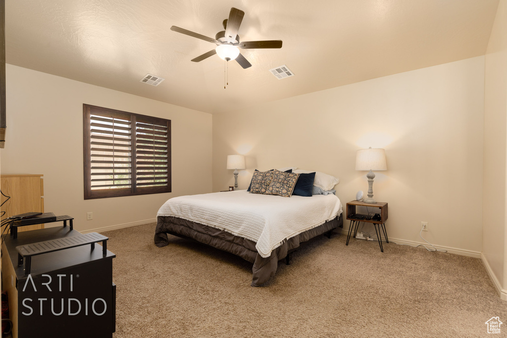 Carpeted bedroom with baseboards and a ceiling fan