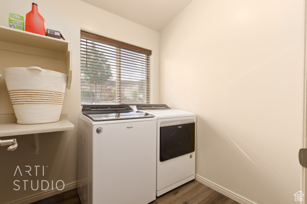 Laundry area with washing machine and dryer, dark wood-type flooring, and baseboards