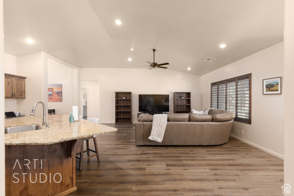 Living room with dark wood-style floors, lofted ceiling, recessed lighting, a ceiling fan, and baseboards