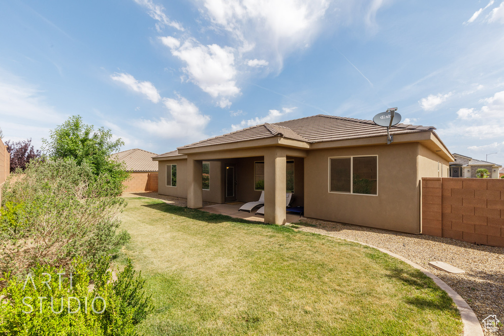 Back of property featuring stucco siding, a patio area, and a tiled roof