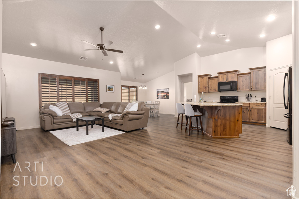 Living area featuring ceiling fan, wood finished floors, high vaulted ceiling, baseboards, and recessed lighting