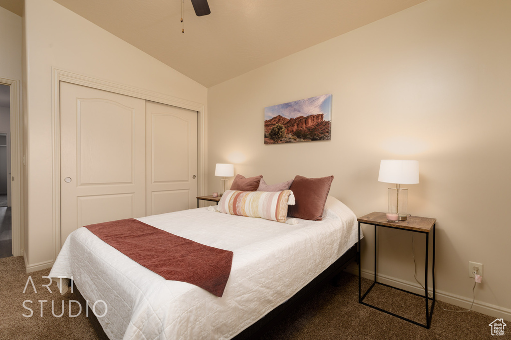 Bedroom featuring carpet floors, lofted ceiling, a closet, baseboards, and a ceiling fan