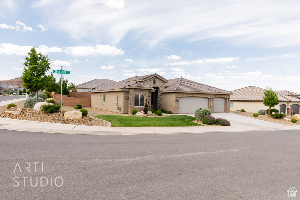 View of front of property featuring stone siding, a garage, driveway, stucco siding, and a tiled roof
