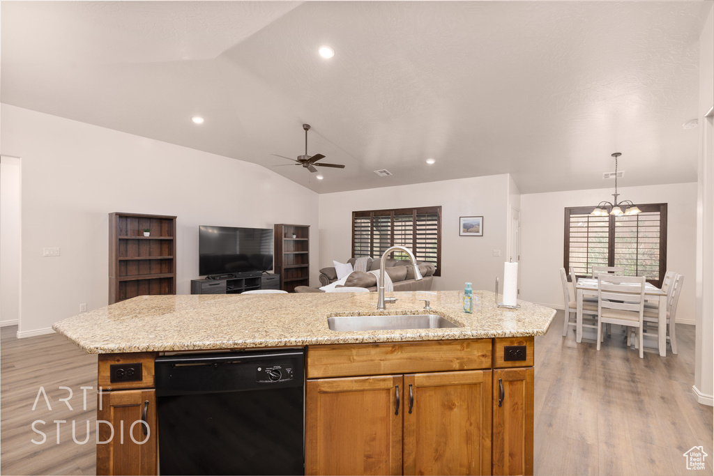 Kitchen with black dishwasher, a sink, light wood-style floors, lofted ceiling, and open floor plan