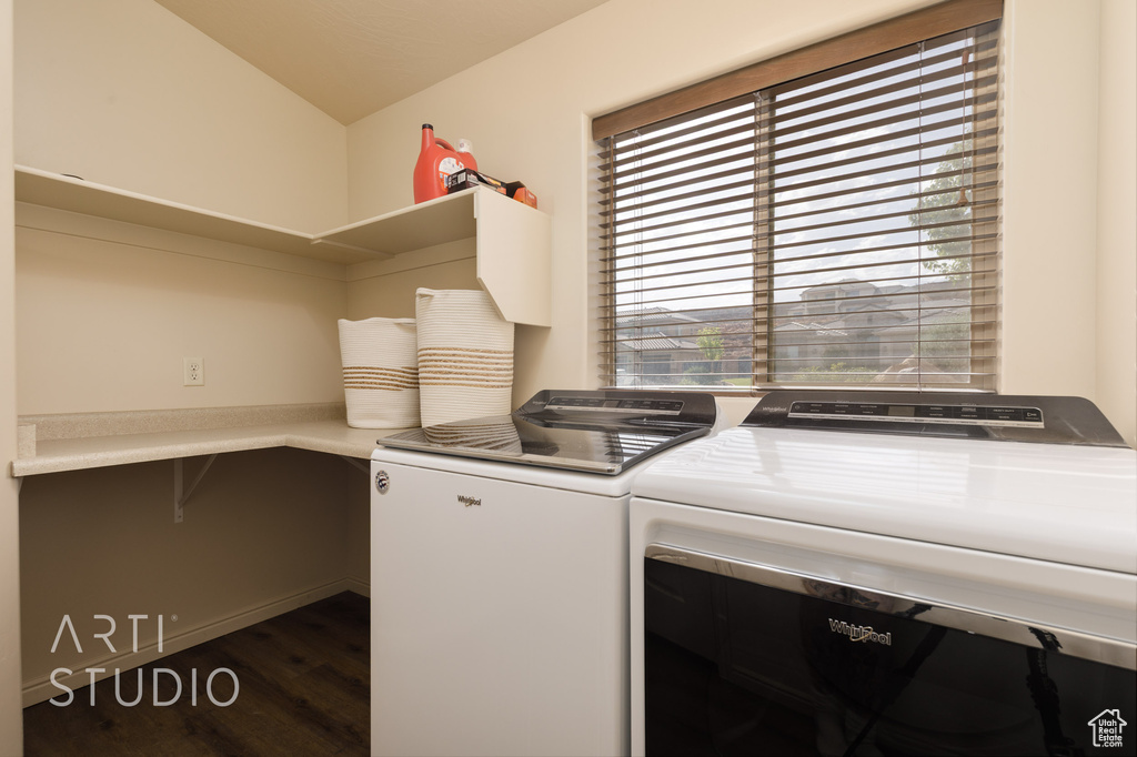 Laundry area featuring washer and dryer and dark wood-type flooring