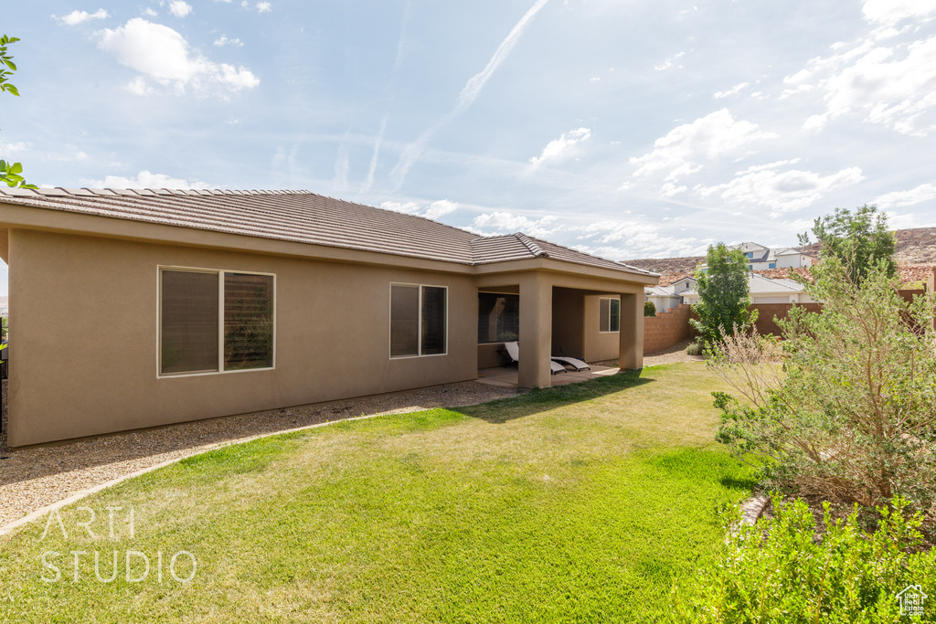Back of property with stucco siding and a tiled roof