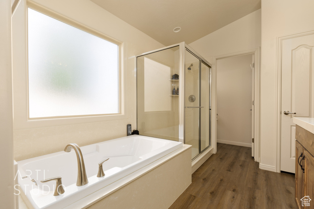 Full bathroom featuring a stall shower, a garden tub, wood finished floors, and vanity