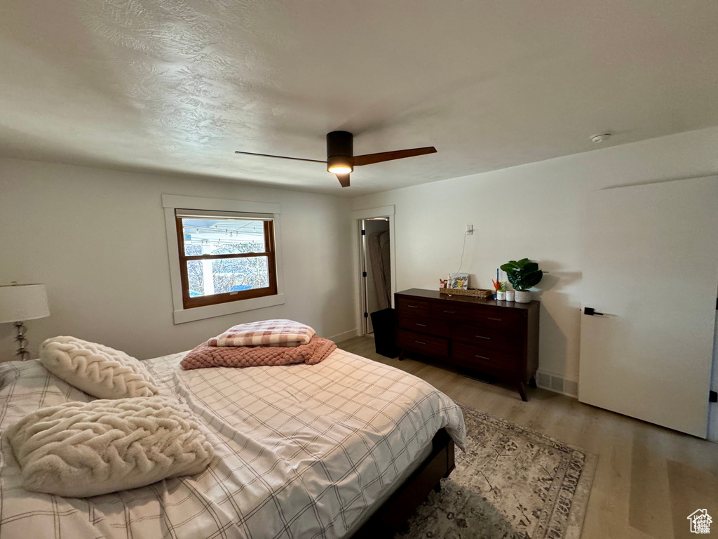 Bedroom with light wood-style flooring, ceiling fan, and baseboards