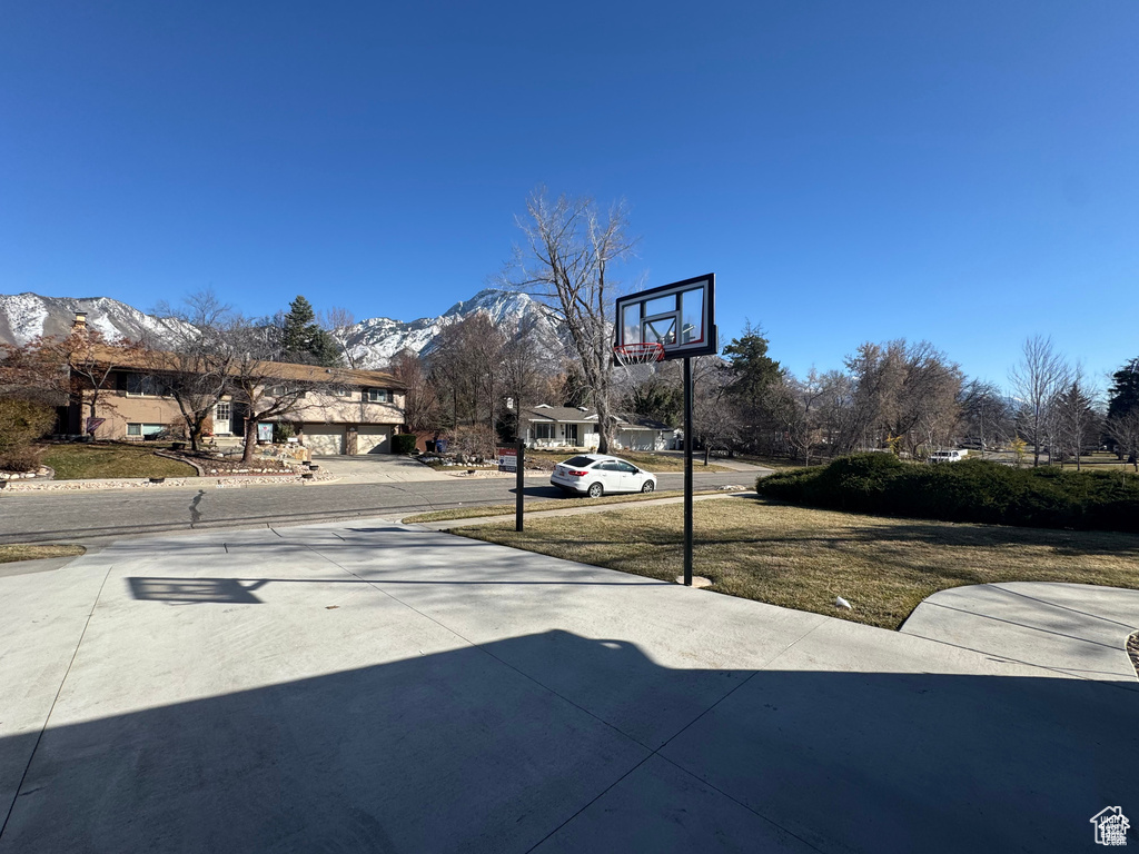 View of basketball court featuring a mountain view and a lawn