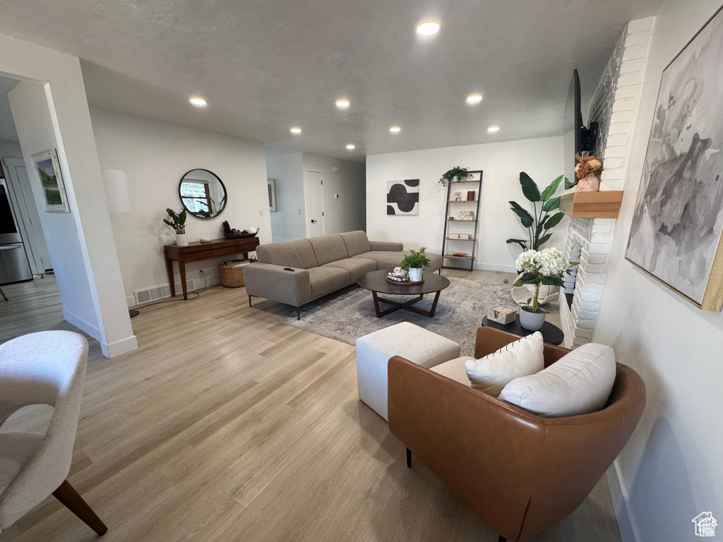 Living area with recessed lighting, light wood finished floors, and baseboards
