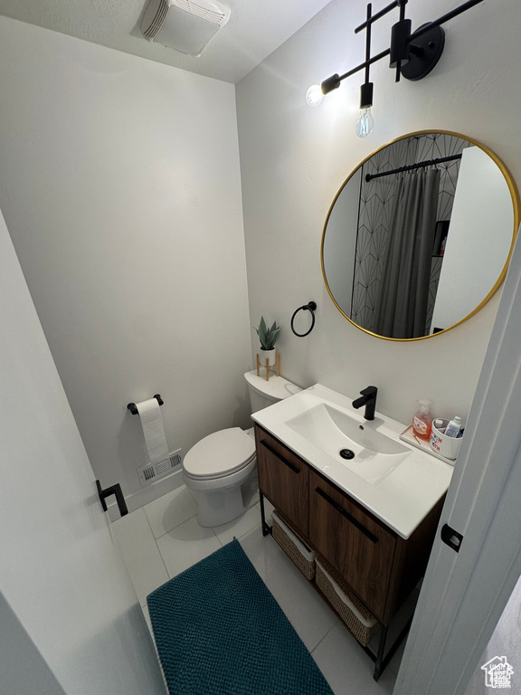 Bathroom featuring vanity, toilet, tile patterned floors, and a shower with curtain