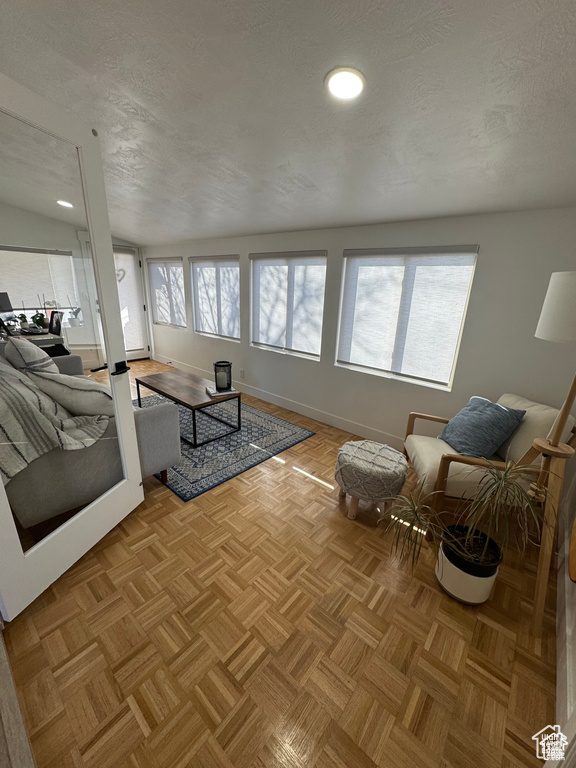 Living room featuring a textured ceiling and baseboards