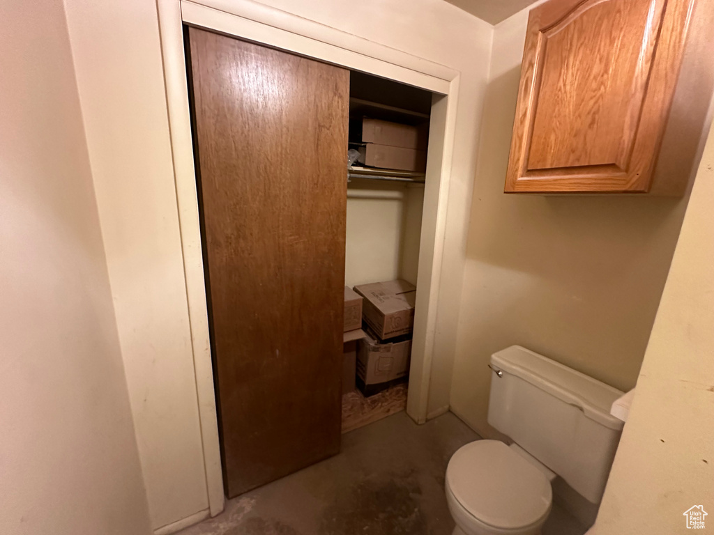 Bathroom with unfinished concrete floors and toilet