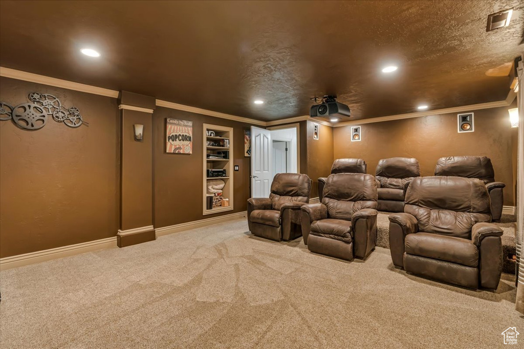 Carpeted cinema room with recessed lighting, ornamental molding, baseboards, built in features, and a textured ceiling
