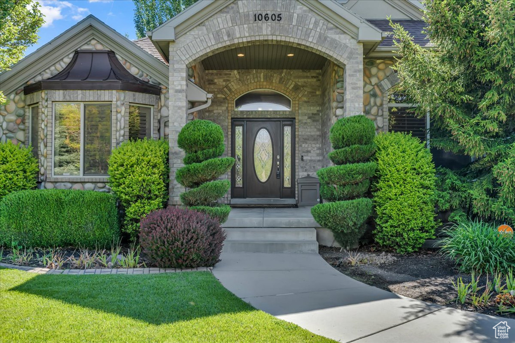 View of exterior entry featuring stone siding and brick siding