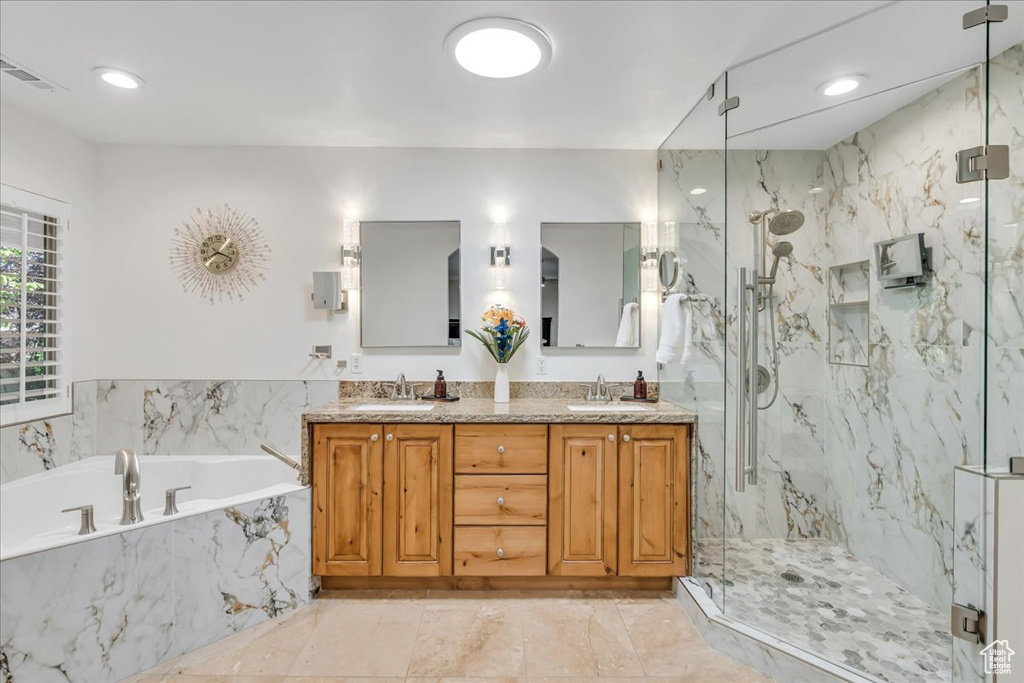 Bathroom featuring a garden tub, a marble finish shower, double vanity, marble finish flooring, and recessed lighting