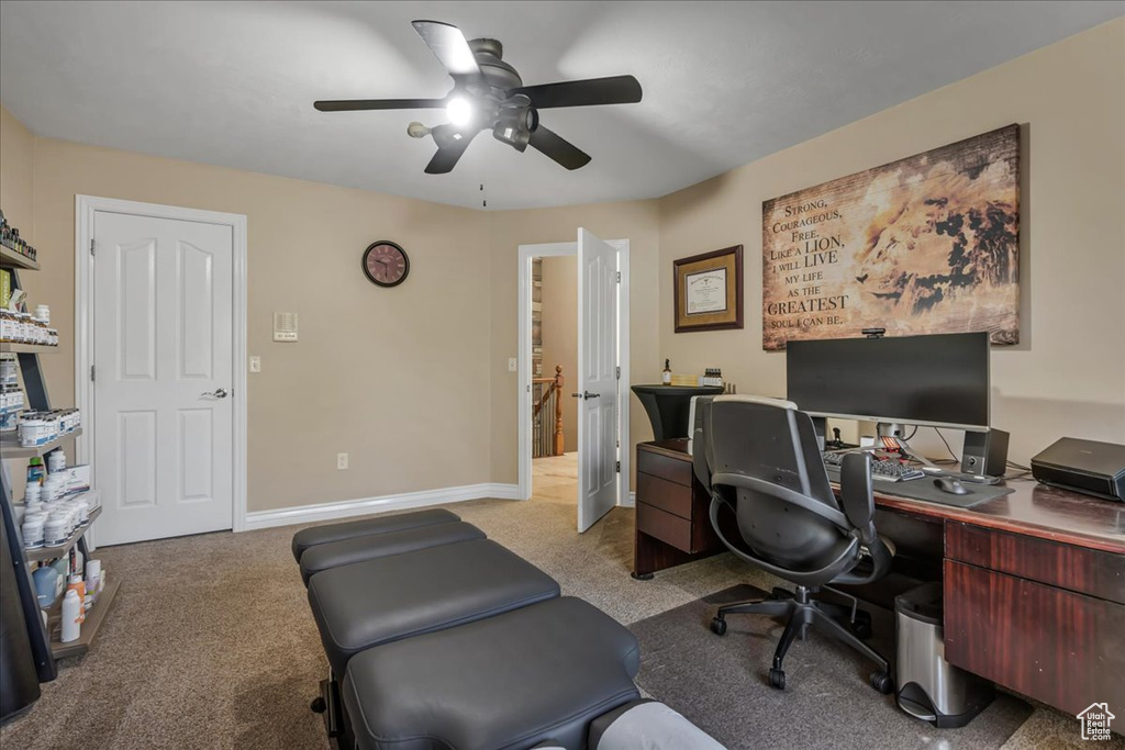 Home office with ceiling fan, light colored carpet, and baseboards