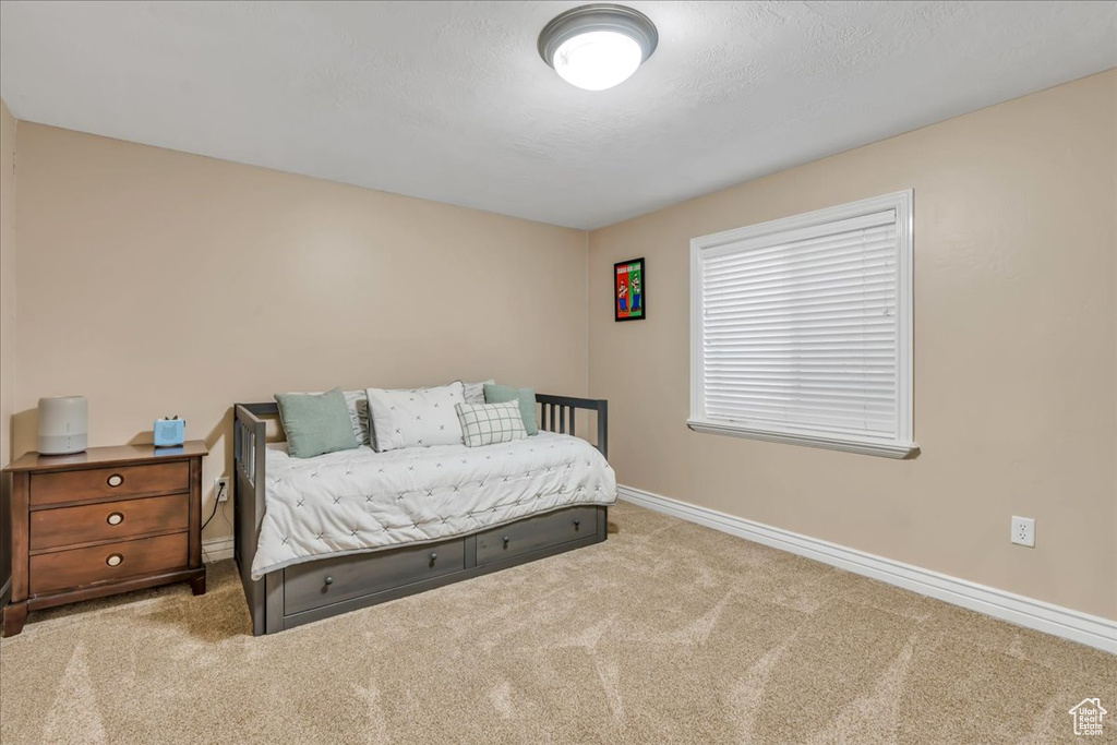 Bedroom featuring carpet flooring and baseboards