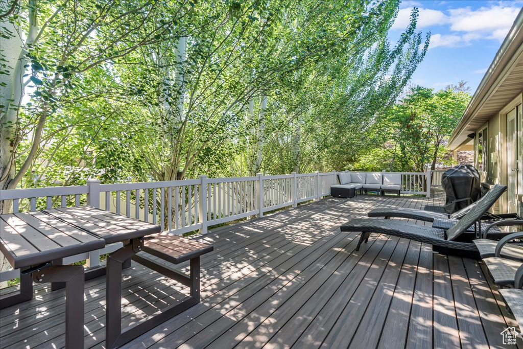 Wooden terrace with an outdoor hangout area and grilling area