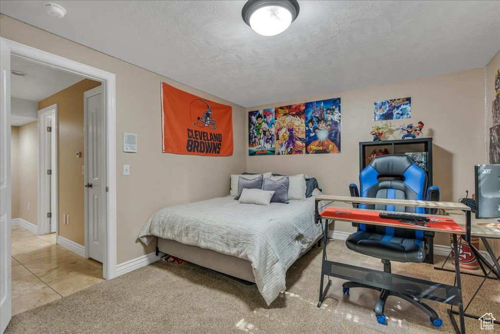 Bedroom featuring baseboards, carpet flooring, and a textured ceiling