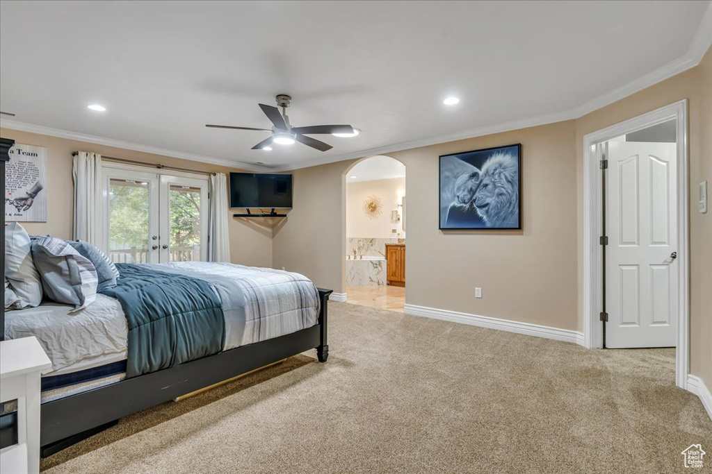 Bedroom featuring arched walkways, ornamental molding, access to exterior, baseboards, and light colored carpet