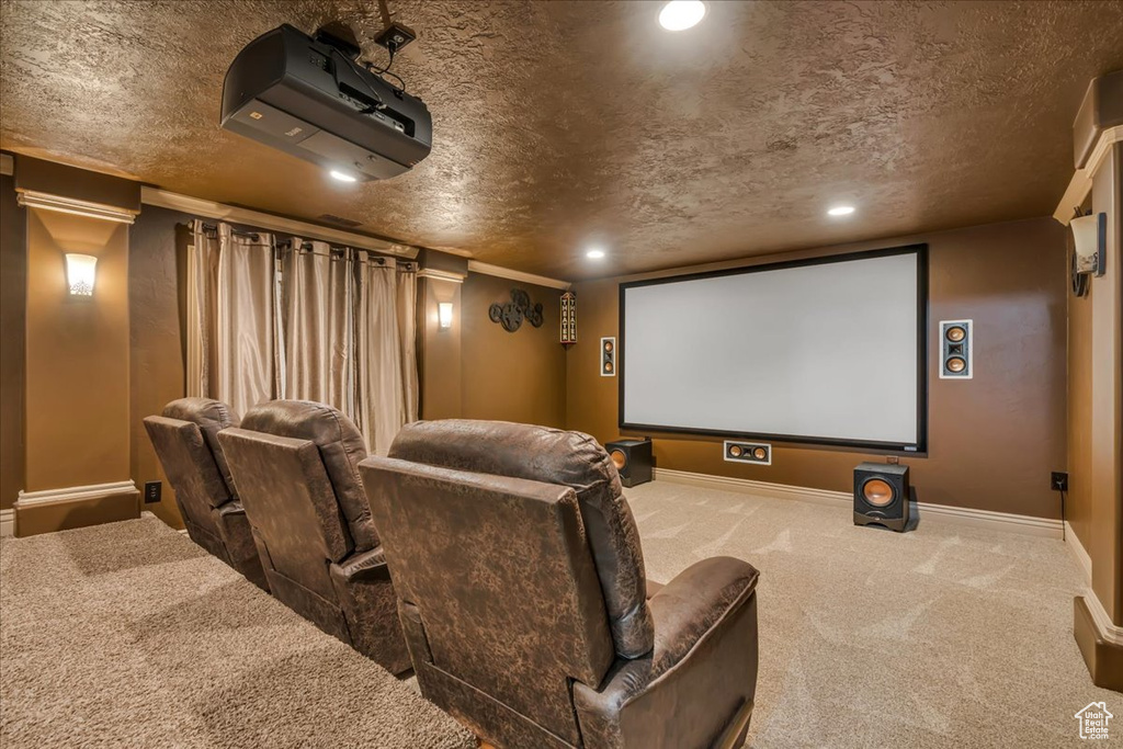 Carpeted home theater room with baseboards, recessed lighting, and a textured ceiling