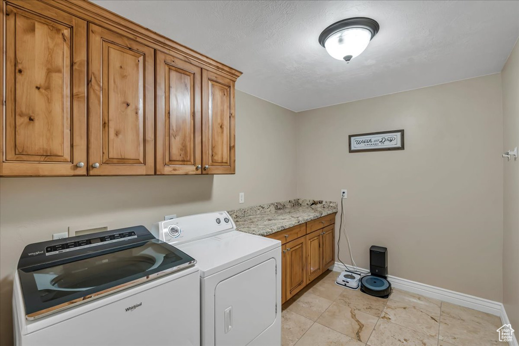 Laundry room with cabinet space, independent washer and dryer, and baseboards