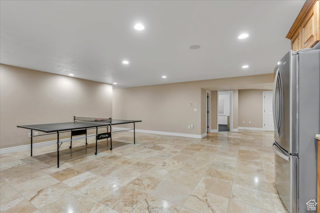 Playroom featuring baseboards, recessed lighting, and light stone finish flooring